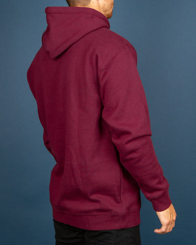 The Pass~Port Olive Puff Print Hoodie in Marron brings a comfortable and warm pullover style. Constructed from a premium cotton blend with a cosy fleece interior, this hoodie is quipped with an adjustable drawstring hood, front pouch pocket and ribbed trims. Signed off and stamped with a custom puff print logo graphic on the centre chest.